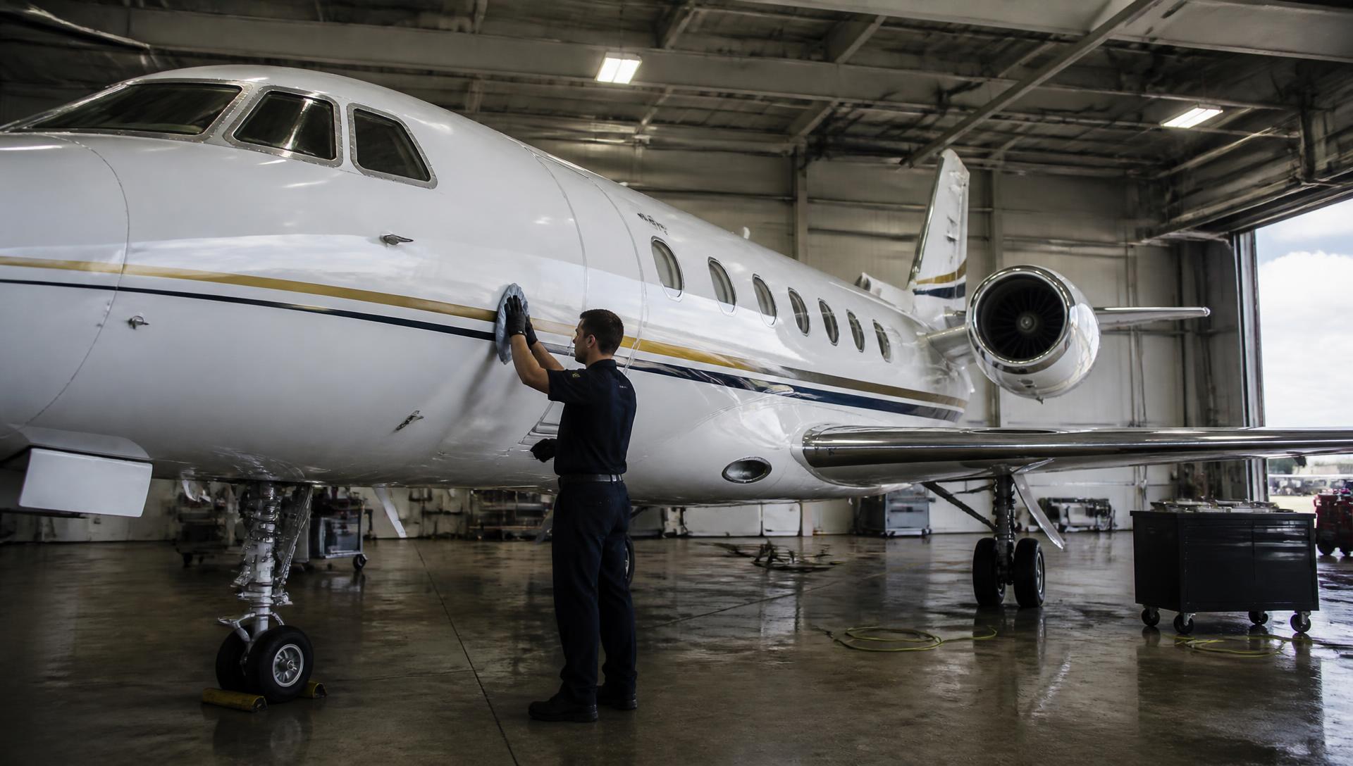 Freshly detailed private jet inside a dark hangar